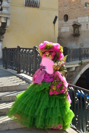 VENICE - MARCH 7: An unidentified masked person in costume on the bridge via Venice canal during the Carnival on March 7, 2011. The 2011 carnival was held from February 26th to March 8th.のeditorial素材