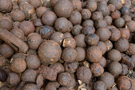 Big pile of an old rusty cannonballs 