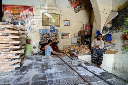 SANAA, YEMEN - MARCH 6, 2010  Unknown men cook breads in the street bakery in Sanaa  Inhabited for more than 2 500 years at an altitude of 2 200 m, the Old City of Sanaa is a UNESCO World Heritage City のeditorial素材