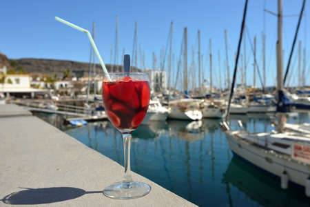 Full glass of sangria against marina of Puerto de Mogan  Gran Canaria, Spainの写真素材