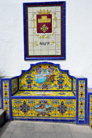 FIRGAS, SPAIN - FEB 26, 2014   Fragment of an architectural monument in Firgas, bench from Andalusian tiles depicting the city Agaete  One from main attraction in this cityのeditorial素材