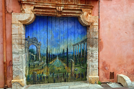 ROUSSILLON, FRANCE - JUL 07, 2014  Painting of French garden with ruins of Roman temple on door of old house  Roussillon ocher village is included in list of  The most beautiful villages of France のeditorial素材
