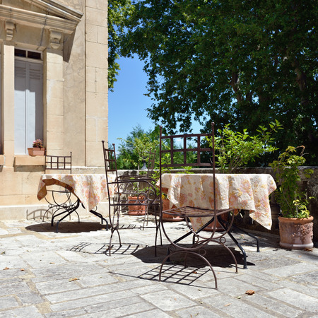 Empty coffee terrace with tables and chairs in village, Provence,  Franceのeditorial素材