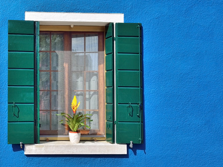 Burano island, Venice. Decorated window with bouquet of flowers. Colorful houses island and landmark...