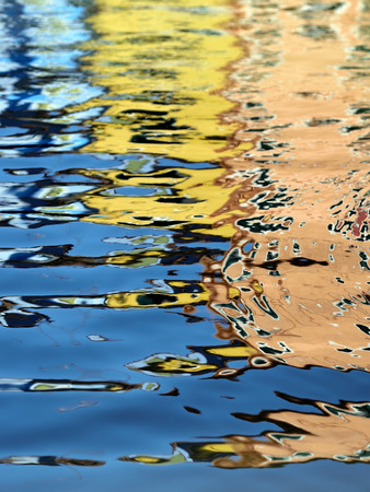 Blured abstract background. The reflection of a colorful houses in water canal, Burano island, Venice,  landmark of Veneto region, Italyの写真素材