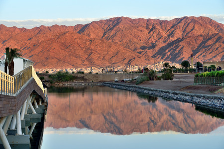 Sunset in Eilat city, famous international resort - the southest city of Israel. Red mountains reflect on the sea gulfのeditorial素材