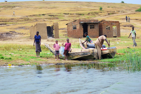 UGANDA AUG 29 2010: Local people shown on the Kazinga channel shore at twilight. The Kazinga channel is the only source of transportation in this region of central Africaのeditorial素材