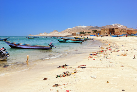 SOCOTRA, YEMEN - MAR 08, 2010: Fishing boats and beach covered with rubbish in fishing village. Yemen one from the most poorest country in the Worldのeditorial素材
