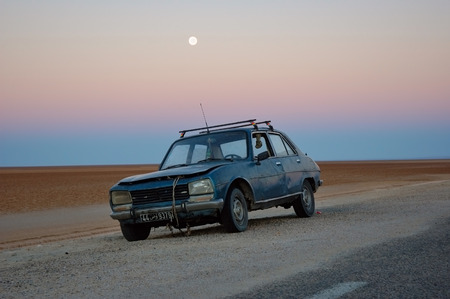 TUNISIA, SAHARA DESERT - SEPT 29, 2004: Abandoned old rusty car in the desert near Libyan border. Now it area can be very danger because of civil warのeditorial素材