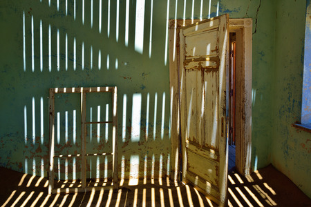 The abandoned ghost diamond town of Kolmanskop in Namibia, which is slowly being swallowed by the desertの写真素材