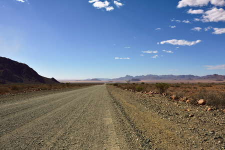 Beautiful landscape the Namib-Naukluft National Park, where the mountains of the Namib desert meet its plains. Dirt road to mountainsの写真素材