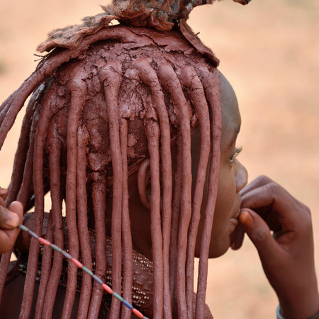 KAMANJAB, NAMIBIA - FEB 1, 2016: Young unidentified Himba woman with the typical hairstyle shown...