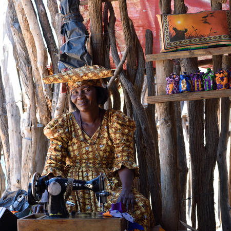 KAOKOLAND, NAMIBIA - FEB 1, 2016: Unidentified Herero Woman in traditional clothes with sewing machine. The Herero belonging to the Bantu group, with about 240,000 members alive today.のeditorial素材