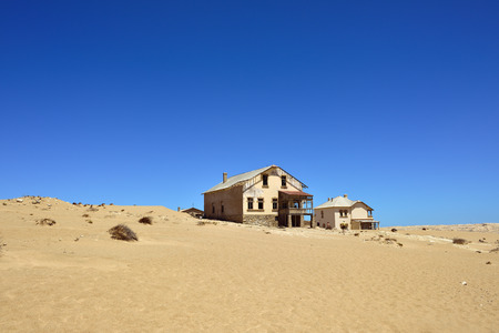 The abandoned ghost diamond town of Kolmanskop in Namibia, which is slowly being swallowed by the...
