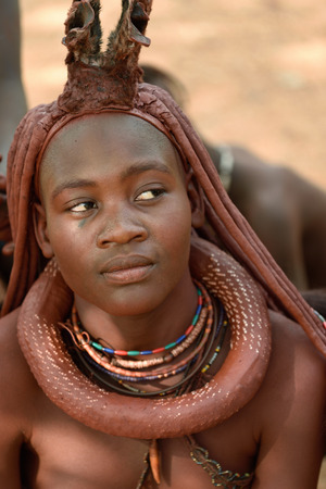 KAMANJAB, NAMIBIA - FEB 1, 2016: Young unidentified Himba woman with the typical necklace and hairstyle shown in himba tribe villageのeditorial素材