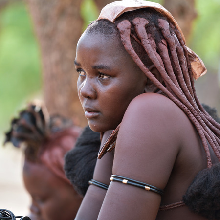 KAMANJAB, NAMIBIA - FEB 1, 2016: Unidentified Himba woman with the typical necklace and hairstyle shown in himba tribe villageのeditorial素材