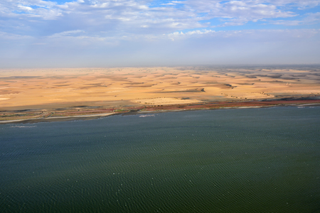 Aerial view on the Sceleton coast in Namibia where dunes of the Namib desert meet with Atlantic ocean, Africaの写真素材