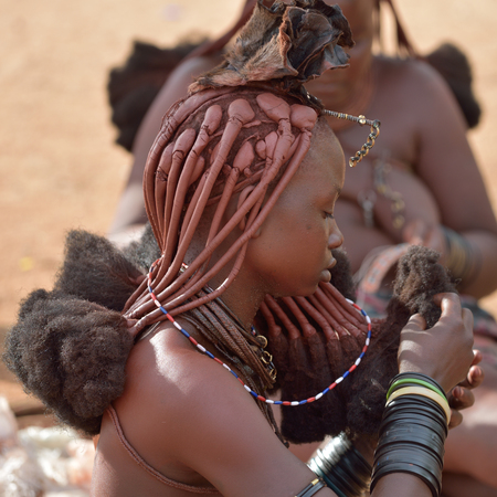 KAMANJAB, NAMIBIA - FEB 1, 2016: Young unidentified Himba woman with the typical hairstyle shown in himba tribe villageのeditorial素材