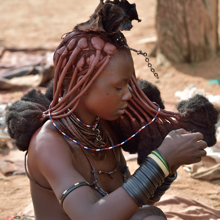 KAMANJAB, NAMIBIA - FEB 1, 2016: Young unidentified Himba woman with the typical hairstyle shown in...