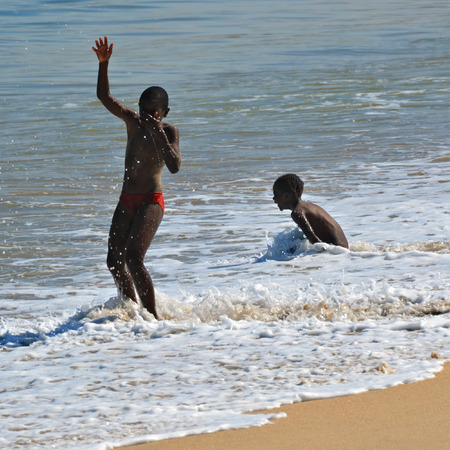 SWAKOPMUND, NAMIBIA - JAN 31, 2016: Children have a fun in water on the beach in Swakopmund. Swakopmund was founded in 1892, by Captain Curt von Francois as the main harbour of German South West Africaのeditorial素材
