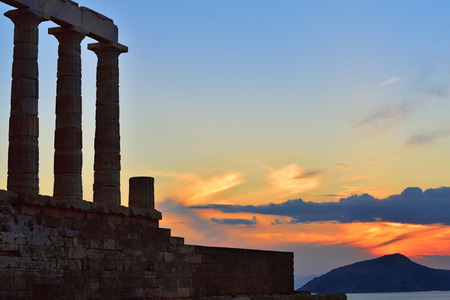 Greece. Cape Sounion - Ruins of an ancient Greek temple of Poseidon against beautiful sunset. This place considered to view the most beautiful sunsets in Greeceの写真素材