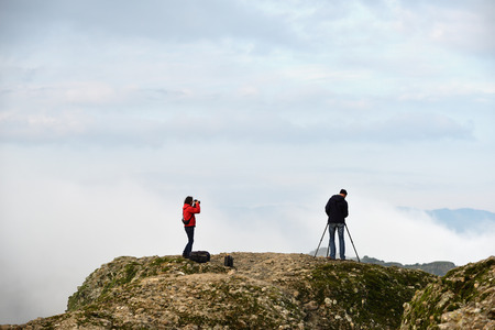 Kastraki, Greece - Sept 27, 2016: Two unidentified photographer, a man and woman taking a pictures of the Meteora mountains at sunriseのeditorial素材
