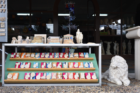 Corinth, Greece - Sept 12, 2016: Greek souvenir in various form displayed in a small shop on public street. Small statues of ancient heroes and gods the most popular souvenir in Greeceのeditorial素材