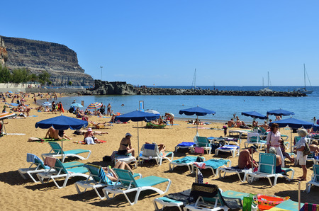 PUERTO DE MOGAN, SPAIN - FEB 19 2014: Public beach of Puerto de Mogan, Gran Canaria. It is of most popular place with shopping facilities, restaurants and pubsのeditorial素材