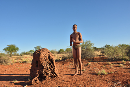 KALAHARI, NAMIBIA - JAN 24, 2016: Bushman hunter near termite mound. The San people, also known as Bushmen are members of various indigenous hunter-gatherer peoples of Southern Africaのeditorial素材