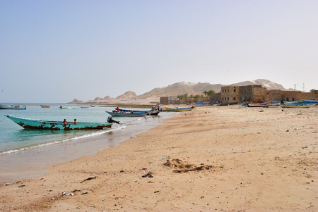 SOCOTRA, YEMEN - MAR 08, 2010: Fishing boats and beach covered with rubbish in a fishing village Qalansiya in the lagoon Detwah. Yemen one of the most poorest country in the Worldのeditorial素材