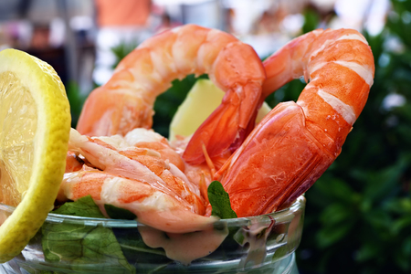 Shrimp cocktail with lemon and sauce with outdoor restaurant lights in background. Small depth of fieldの写真素材
