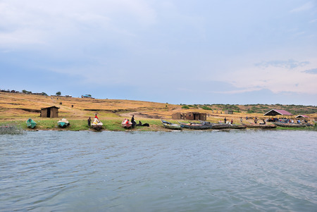 Uganda - Aug 29, 2010: Local people shown on the Kazinga channel shore at twilight. The Kazinga channel is the only source of transportation in this region of central Africaのeditorial素材