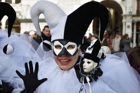 Venice, Italy - Mar 7, 2011: Unidentified masked person in Arlecchino costume among crowd in St. Mark's Square during the Carnival. The 2011 carnival was held from February 26th to March 8thのeditorial素材