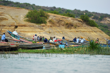 Kazinga, Uganda - Aug 29, 2010: Local people shown on the Kazinga channel shore at twilight. The Kazinga channel  is the only source of transportation in this region of central Africaのeditorial素材