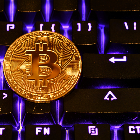 Bitcoin. Crypto currency Bitcoin, BTC, Bit Coin. Macro shot of Bitcoin golden coin on the illuminated keyboard background. Blockchain technology, bitcoin mining conceptの写真素材