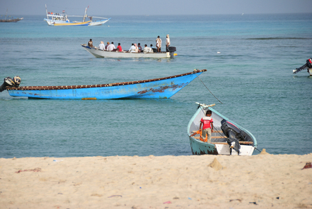 Al Hodeidah, Socotra, Yemen - March 08, 2010: Fishing boats and local people on the beach at the early morning in a fishing village at the Socotra island.のeditorial素材
