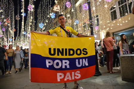 Moscow, Russia - June 26, 2018: Colombian football fan on the night streets of Moscow. The slogan on the flag means United By a Country. FIFA world cup, Mundial 2018のeditorial素材