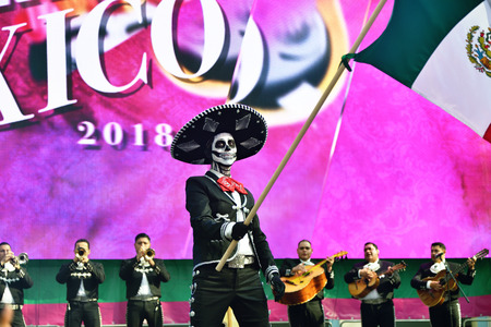 Moscow, Russia - June 29, 2018: Man in hat with sugar skull makeup waving mexican flag during Dia de los Muertos Mexican parade. Day of The Deadのeditorial素材