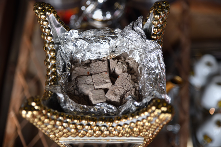 The bakhoor burned in a vintage mabkhara or dabqaad, a traditional arabic incense burner (censer)....