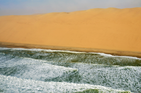 Aerial view on the coast in Namibia where dunes of the Namib desert meet with Atlantic ocean, Africaの写真素材