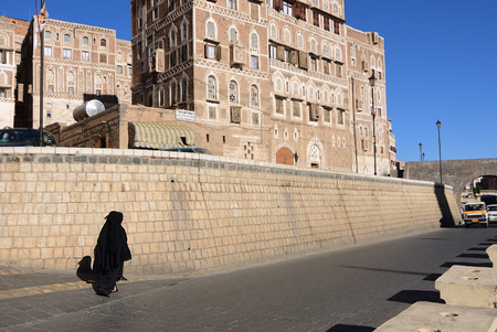 Sanaa, Yemen - March 13, 2010: Two women in a black burka Burqa walking down a street in Sanaaのeditorial素材