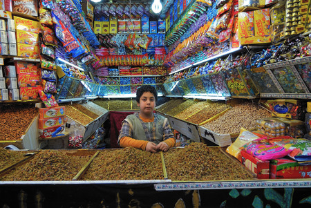 Sanaa, Yemen - March 6, 2010: Unidentified young boy sells the goods at the night market. Open markets play a central role in the social-economic life of one of the poorest countries in the Worldのeditorial素材