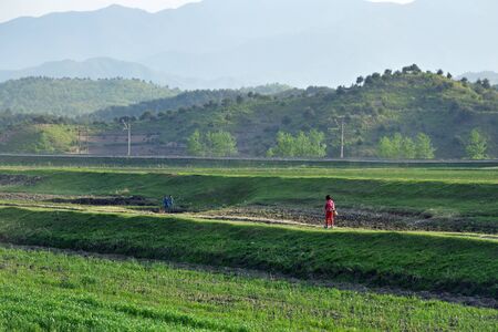North Korea - May 3, 2019: Countryside landscape, DPRK. Country life. Children walk along the railway ÑÐ¾ home from schoolのeditorial素材