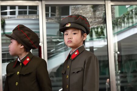 Pyongyang, North Korea - May 1, 2019: Two young girls dressed in uniform of the korean people army on the Pyongyang streetのeditorial素材