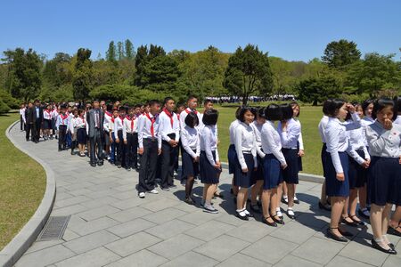 North Korea, Pyongyang - May 1, 2019: A group of North Korean peoples adults and children visit the Mangyongdae village, birthplace of Kim Il Sung.  DPRKのeditorial素材