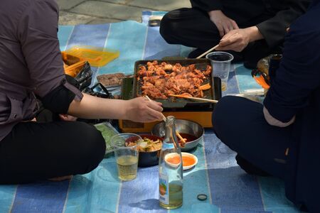 Pyongyang, North Korea - May 1, 2019: People having fun outdoor at bbq picnic with snacks, food and drink. Local people enjoying spring time together at barbecue park partyのeditorial素材