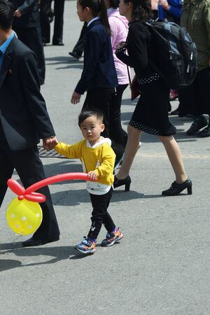 Pyongyang, North Korea - May 1, 2019: Pyongyang street. Son holds hand of his fatherのeditorial素材