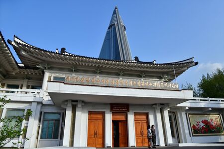Pyongyang, North Korea - April  29, 2019: Building of the Pyongyang Embroidery Institute, Ryugyong Hotel skyscraper at backgroundのeditorial素材