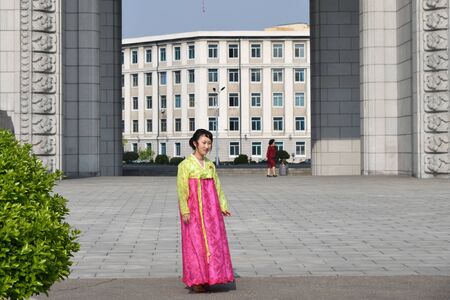 Pyongyang, North Korea - May 1, 2019: Local girl in traditional korean dress, member of the Korean Workers Party shown on a city streetのeditorial素材
