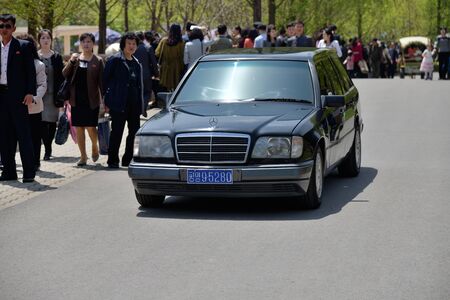 Pyongyang, North Korea - May 1, 2019: Car on the street in Pyongyang. Pedestrians walk down the sidewalkのeditorial素材